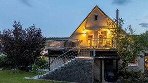 Ein zweistöckiges Haus mit Balkon und einer Treppe zum Eingang.
