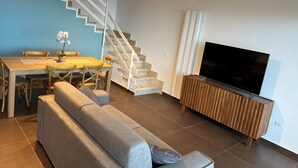 A modern living room with a staircase, a dining area, and a television. - Tiffany Home near Cefalù  (san nicola l'arena)