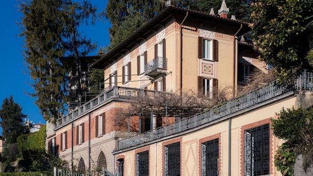 A historic building with a balcony, arched windows, and a tiled facade.