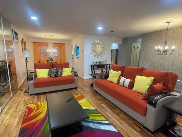 A living room with two sofas, a coffee table, and a colorful rug. - Comfort Haven/King-Sized Bed/Near Nautical Mile- 20 minutes from JFK (Baldwin)