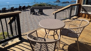 A wooden deck with wicker furniture overlooking the ocean. - Sparkling Clean, Private & Quiet! Amazing Ocean Views [3] (Brookings)