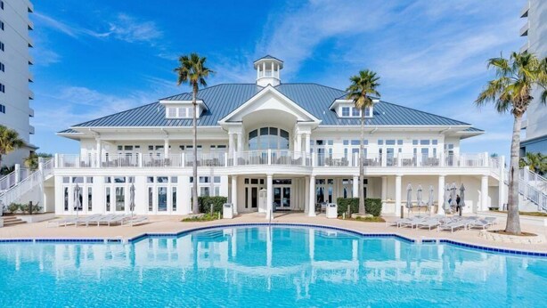 A large, two-story building with a swimming pool in front.