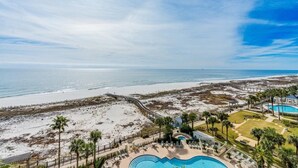 A resort with a swimming pool, beach access, and a view of the ocean.