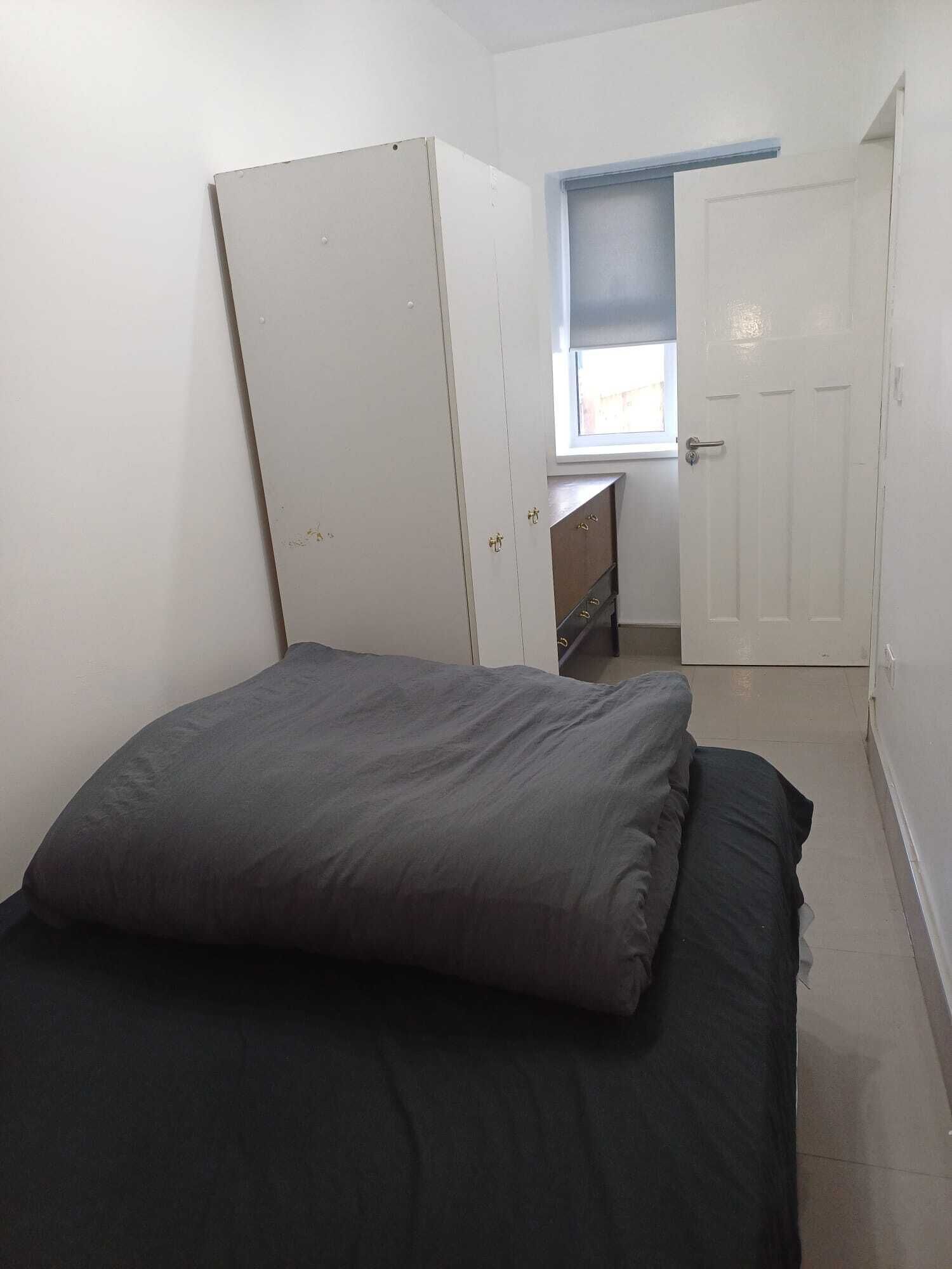 Una camera da letto con un letto, un armadio, una finestra e una porta.