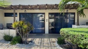 A modern building with a stone patio, a covered entrance, and a small outdoor seating area. - Awesome Villa 2 Chic Pool & Hot Tub  (El Sargento)