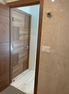 Stylish hallway leads to a room with a geometric-patterned door.