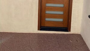 Una puerta de madera con un panel de vidrio y un pequeño marco de fotos en la pared de al lado.