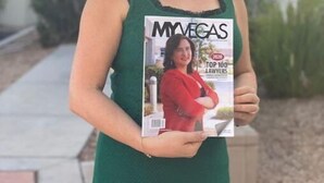 Una persona sosteniendo una revista titulada 'MYVEGA' con '100 MEJORES ABOGADOS' en la portada.