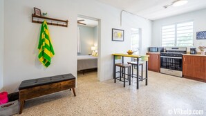 Ein kompakter Wohnraum mit Küchenzeile, Essbereich und Schlafzimmer.