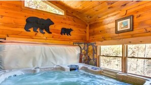 A wooden cabin interior with a hot tub, wooden walls, and a bear silhouette decoration. - Katahdin Cabin Rustic Romance + Indoor Hot Tub Near Town (Blue Ridge)