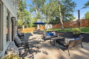 An outdoor patio with stone flooring, a wooden fence, and a small shed in the background. - The Crestwood House - Family Friendly Retreat with Private Backyard - DCA  (Alexandria)