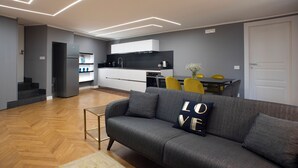 A modern living room with a grey sofa, a small coffee table, and a dining area with yellow chairs. - New apartment in the historic center of Naples, for families or couples.  (Napoli)