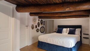 A bedroom with a bed, wooden ceiling beams, and wall-mounted mirrors. - New apartment in the historic center of Naples, for families or couples.  (Napoli)