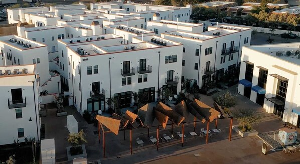 A modern building with multiple floors, outdoor seating areas, and a courtyard.