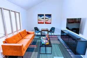Una sala de estar moderna con un sofá, una mesa de centro y un televisor.