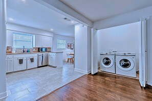 A modern kitchen with white cabinets, a microwave, and a dishwasher.