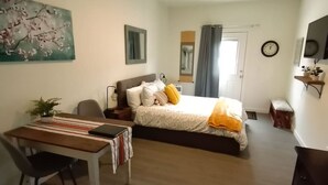 Une chambre à coucher avec un lit, une table de chevet, une chaise et un tableau au mur.