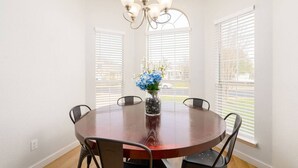 A dining room with a round table, chairs, a chandelier, and a vase with flowers. - Super Clean/ Fun Environment! Low Cleaning Fee! (Georgetown)