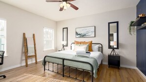 A bedroom with a bed, a ceiling fan, two bedside tables, a nightstand, and a window with blinds. - Super Clean/ Fun Environment! Low Cleaning Fee! (Georgetown)