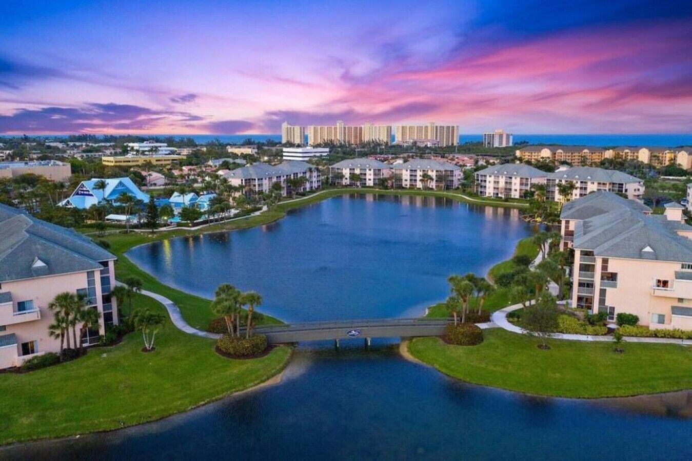 A large rectangular water body surrounded by residential buildings with a bridge in the center.