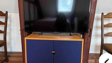 Un televisor de pantalla plana sobre un mueble de madera con un aparador azul debajo.