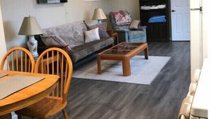 A cozy living room with a sofa, chairs, a coffee table, and a dining table. - 1-bedroom apartment just 6 minutes drive to Lithia & Driveway Fields (Medford)