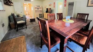 Un coin repas avec une table et des chaises en bois, un téléviseur et une cheminée.