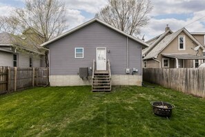 A single-story house with a front door, a small window, and a wooden ladder leading to a porch. - Stadium House - Next to Kernels/Roughriders Arena (Cedar Rapids)