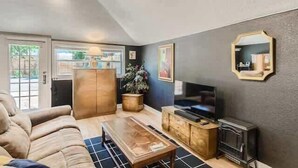 A living room with a sofa, coffee table, TV, and fireplace.