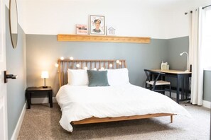 Cozy retreat with a single bed, bedside table, and workspace area.