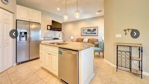 A modern kitchen with a central island, stainless steel appliances, and pendant lighting.