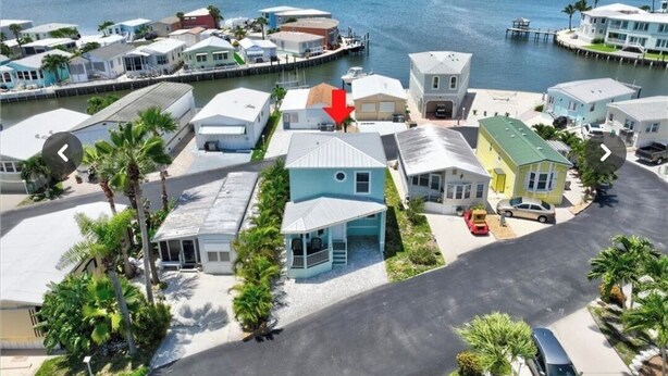 A coastal residential area with houses, a dock, and a marina.