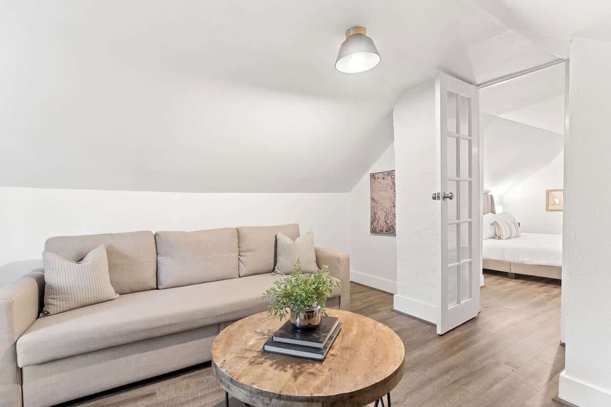 Een moderne loft slaapkamer met een schuine plafond, een groot raam en een inbouwed bed.