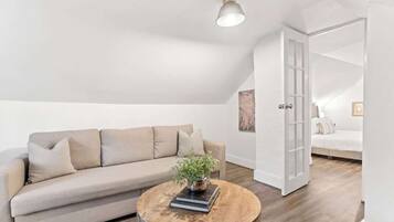Een moderne loft slaapkamer met een schuine plafond, een groot raam en een inbouwed bed.