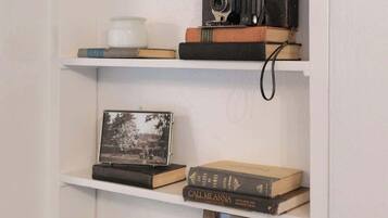 A bookshelf with books, a camera, a picture frame, and decorative items.