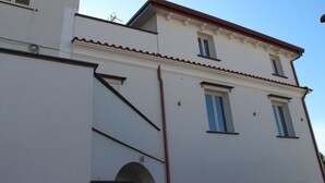 Un immeuble à plusieurs étages, doté d’une façade blanche, d’un toit rouge et de nombreuses fenêtres.