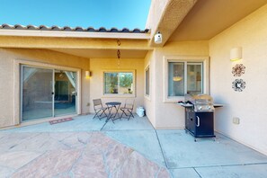 Relax outdoors in this patio area, featuring a barbecue grill and comfortable seating.