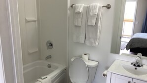 Un bagno con vasca, WC e lavandino.