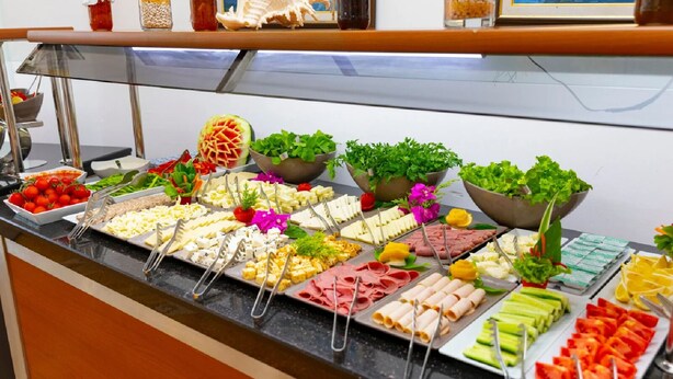 Un buffet proposant une variété d’aliments, notamment des fruits, des légumes, des fromages et des viandes.