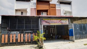 A two-story building with a sign for a homestay and fast food restaurant. - Hotel O Penginapan Syariah Faster Inn (Medan)