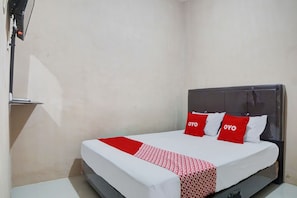 A hotel room with a bed, a bedside table, and a wall-mounted TV. - Hotel O Penginapan Syariah Faster Inn (Medan)