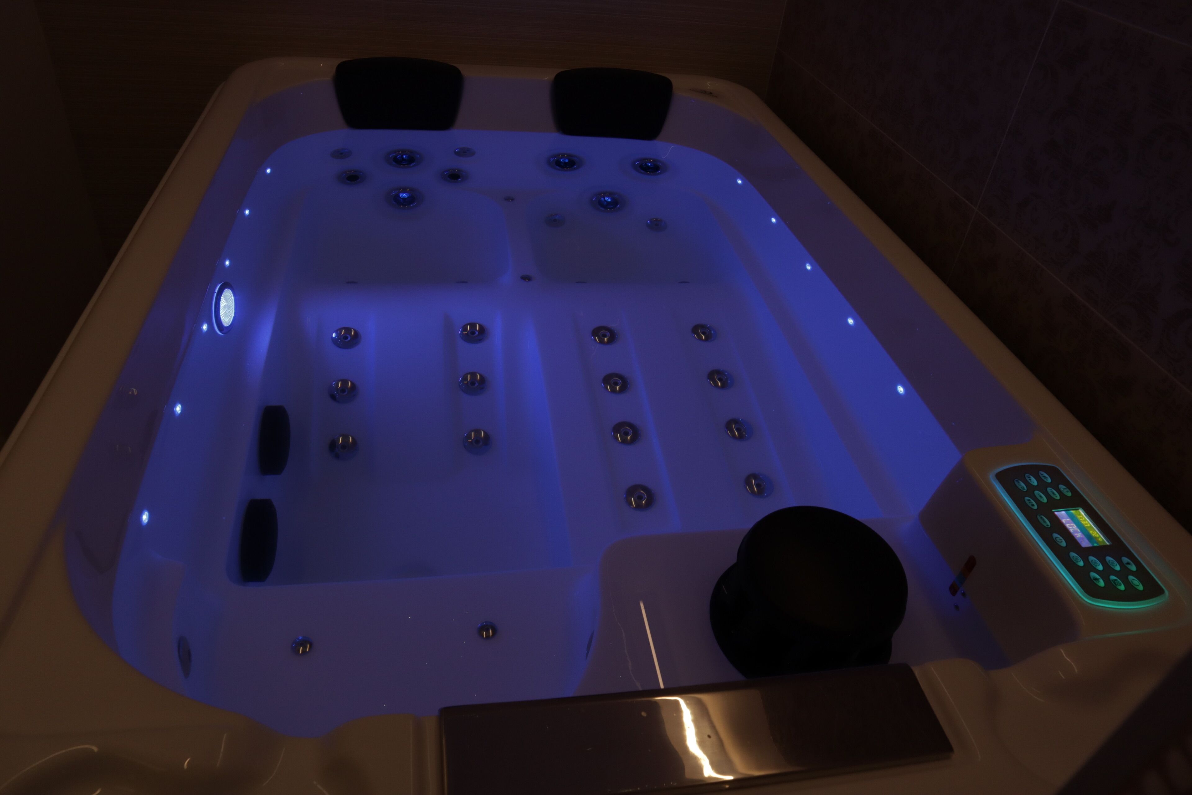 Un bain à remous doté d’un panneau de commande et de plusieurs jets.