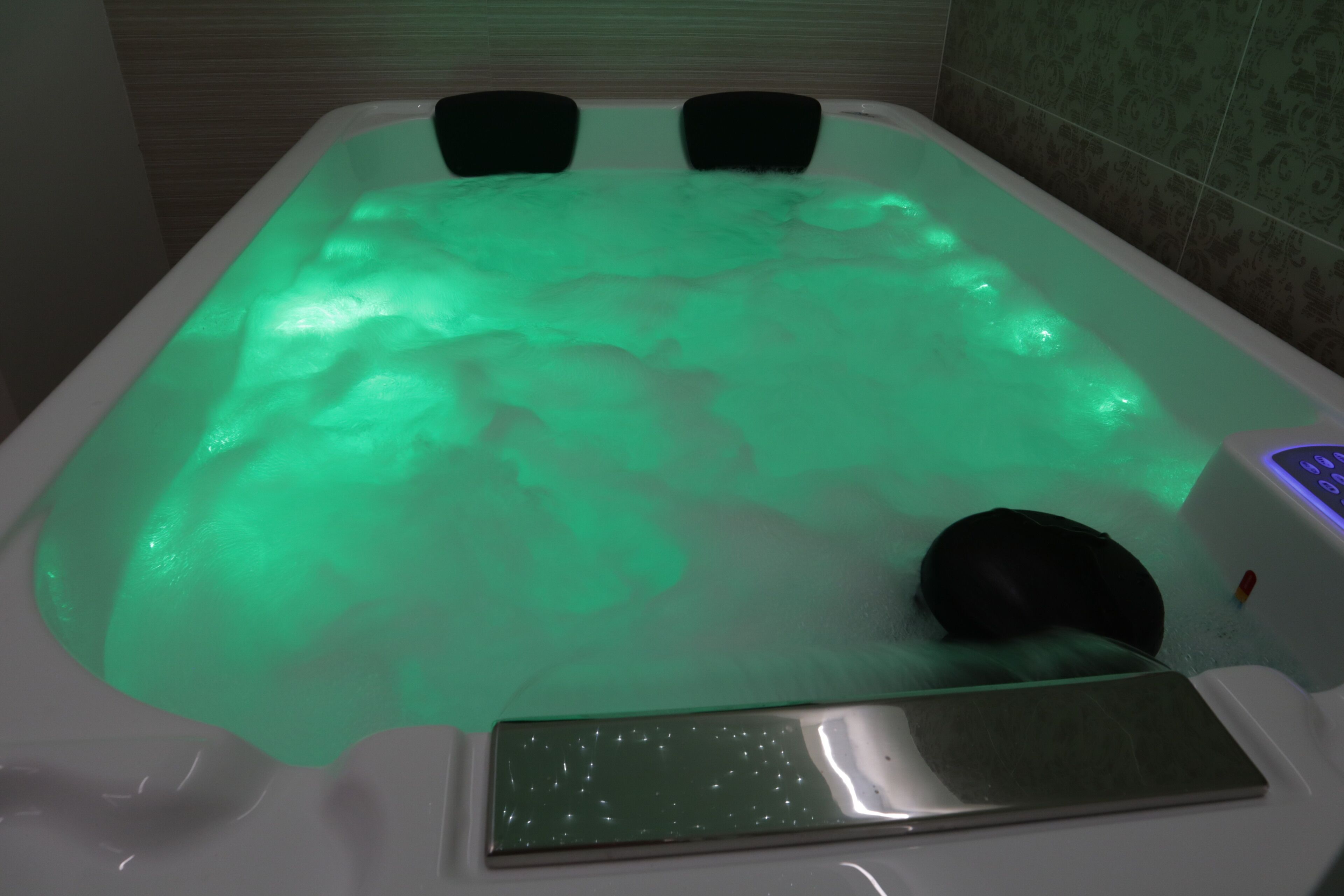 Une baignoire dotée d’un éclairage vert et d’un panneau de commande.
