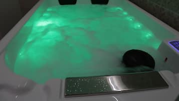 Une baignoire dotée d’un éclairage vert et d’un panneau de commande.