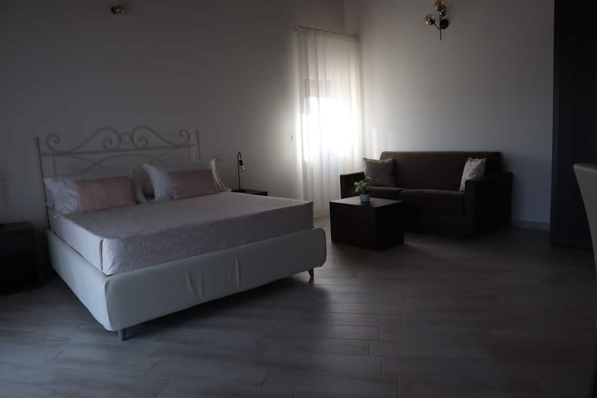 A modern bedroom with a large bed, a sofa, and a coffee table.
