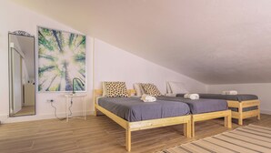 A bedroom with two wooden beds, a large mirror, and a painting of trees. - SandybeachApartment2 in the Golden Island  (Vila Baleira)
