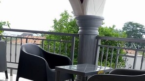 A balcony with a tiled floor, a table, and two chairs. - Cozy Suites (Akure)