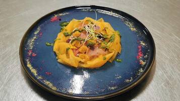 A plate of food with a blue rim and a central yellow dish, garnished with green herbs and sprouts.