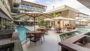 A modern hotel with a pool area, outdoor seating, and a view of the building's architecture. - Sunny Hall Flat by EasyHome (Ipojuca)