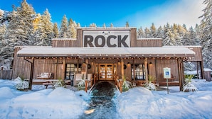 A rustic wooden building with a sign reading "ROCK" and a wheelchair-accessible parking sign.